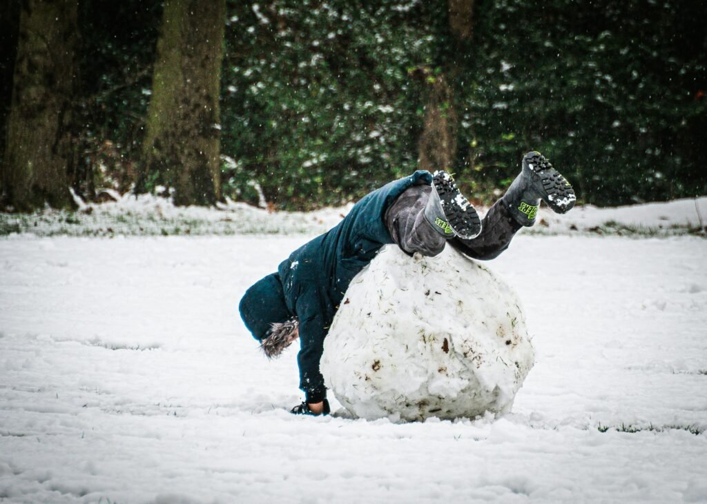 Boy falling over snowball - showing how compound interest snowballs